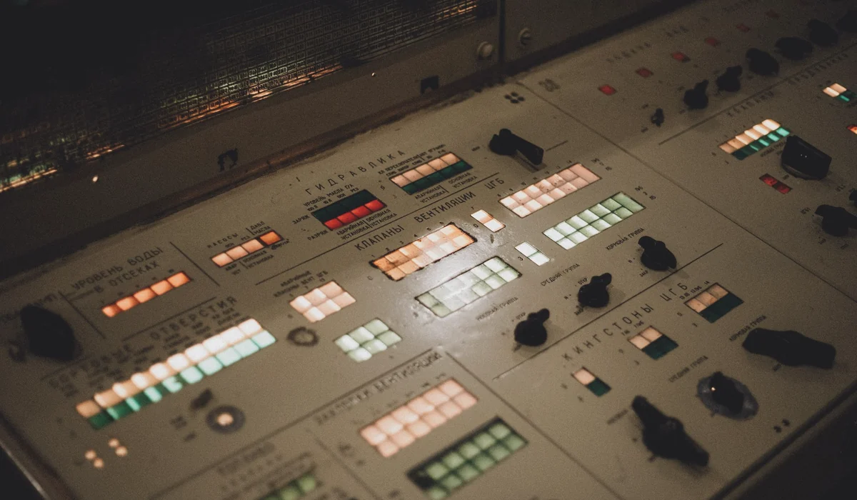 Close-up of an illuminated vintage control panel with various buttons and switches.