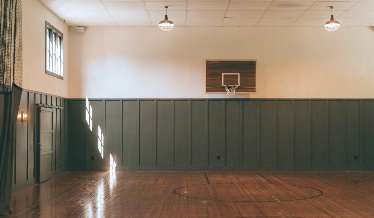 Interior of empty light spacious basketball court with wooden floor in modern sports complex