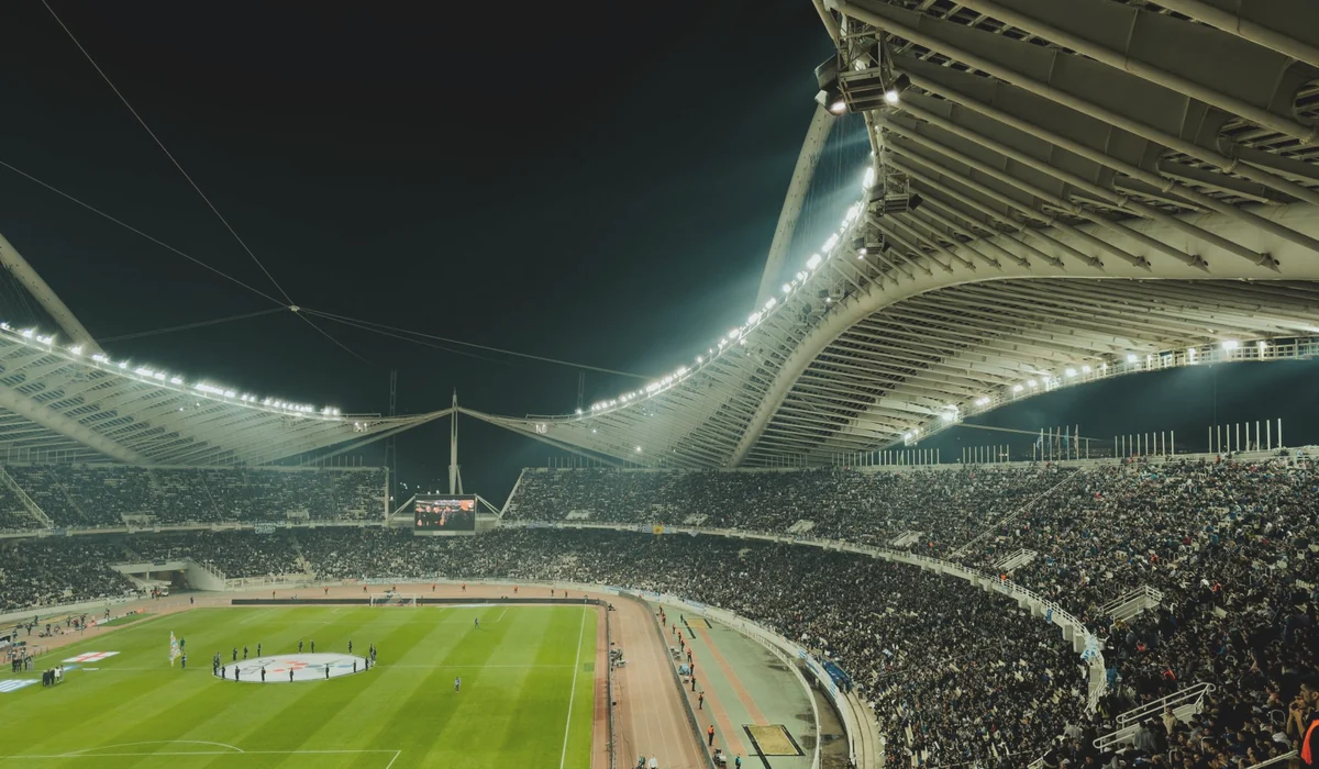 A crowded soccer stadium under bright lights at night, capturing the excitement of a live sports event.