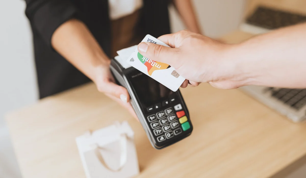 Close-up of contactless payment using a credit card at a modern POS terminal.