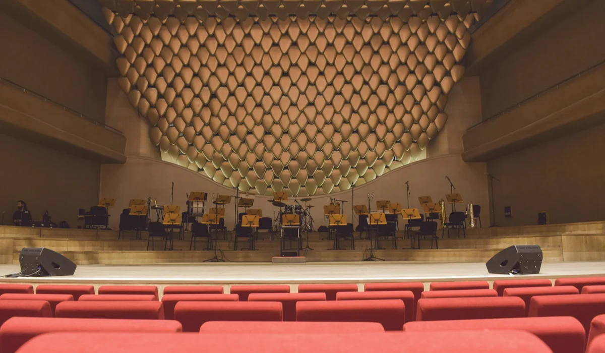 Elegant concert hall interior with empty seats and stage, ready for performance.