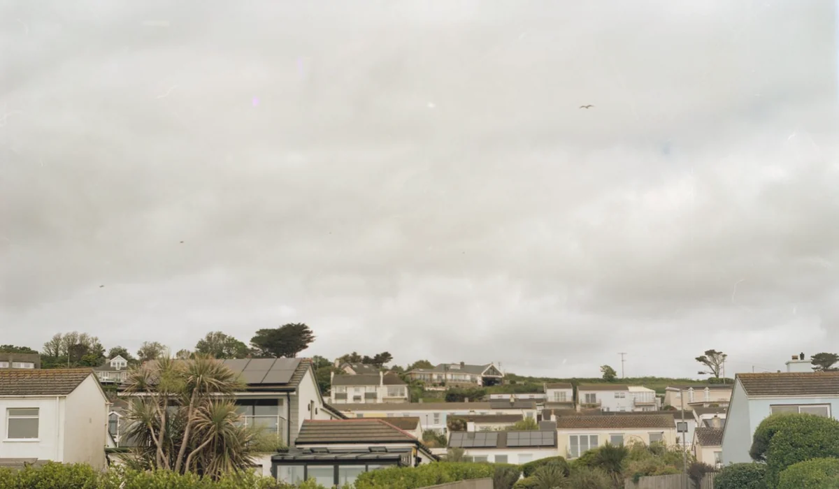Quiet suburban street with houses under an overcast sky.