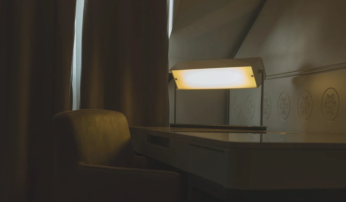Warmly lit home office corner featuring an armchair and desk setup. Perfect for work ambiance.