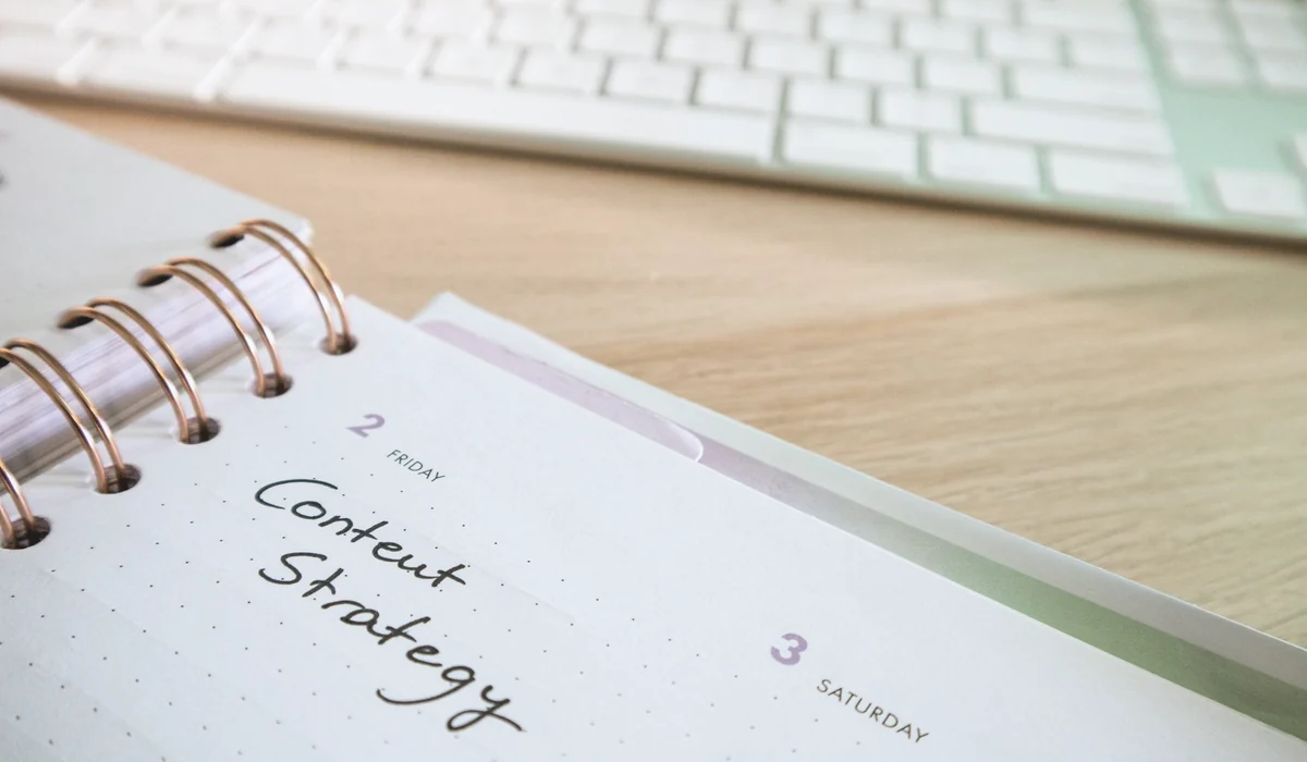 Content strategy written in planner with keyboard on wooden desk